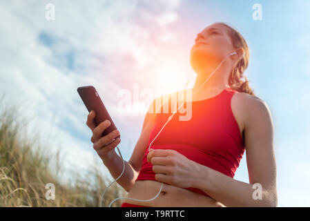 Frau Läufer mit MP3-Player, Smartphone, das Hören von Musik Stockfoto