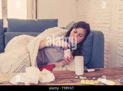 Attraktive Frau unter Decke Unwohlsein mit Kopfschmerzen Wunde Nase hohe Temperatur Gefühl der Müdigkeit und unruhig zu Hause nicht in der Lage zu gehen krank Stockfoto