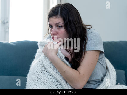 Attraktive Frau unter Decke Unwohlsein mit Kopfschmerzen Wunde Nase hohe Temperatur Gefühl der Müdigkeit und unruhig zu Hause nicht in der Lage zu gehen krank Stockfoto