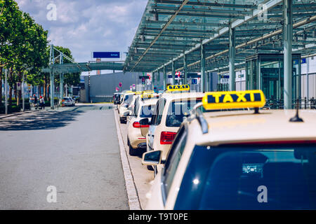 Taxis warten auf Fahrgäste. Gelbes taxi Schild auf cab Autos. Taxi Autos warten Ankunft Passagiere vor Flughafen Tor. Taxis stehen am Flughafen Stockfoto