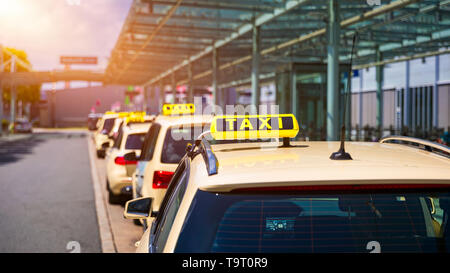 Taxis warten auf Fahrgäste. Gelbes taxi Schild auf cab Autos. Taxi Autos warten Ankunft Passagiere vor Flughafen Tor. Taxis stehen am Flughafen Stockfoto