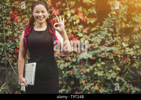 Charmante Middle-Aged asiatischen posiert für die Kamera im Freien Stockfoto