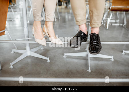 Elegante business Paar an der Bar sitzen, mit Blick auf ihre Beine unter dem Tisch Stockfoto