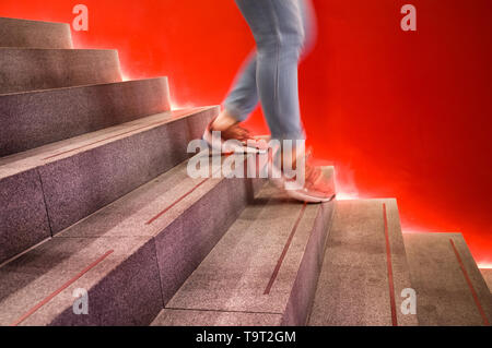 Futuristisch beleuchteten moderne Treppe mit weiblichen Beine wandern. Stockfoto