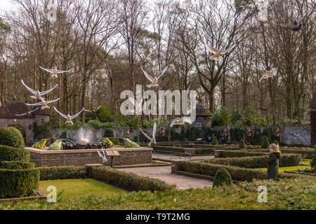 KAATSHEUVEL, Niederlande - 2. März, 2019: Junge Mädchen genießen den Blick auf die weißen Tauben fliegen an der Efteling entfernt. Sonnigen Tag an einem Park Stockfoto