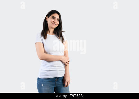 Junge Mädchen mit leeren weißen T-Shirt und eine blaue Jeans. Graue Wand Hintergrund. Stockfoto