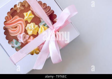 Hausgemachte Marshmallows in verschiedenen Farben sind wunderschön in einem Geschenkkarton verpackt. Weißer Hintergrund. Close-up Stockfoto