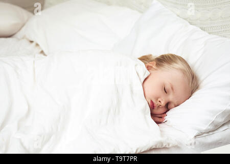 Süßes kleines Kind Mädchen in Ihrem Bett schlafen. Kind wacht auf Stockfoto