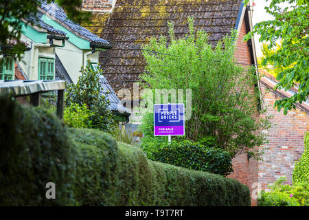 Lila Ziegel Immobilienmakler Zeichen an einem ländlichen Anwesen in der Landschaft von Suffolk. Stockfoto