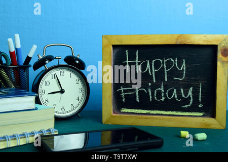 Happy Freitag! Auf dem Hintergrund der Arbeitstisch mit Bürobedarf. Business Konzept Planung auf blauem Hintergrund Stockfoto