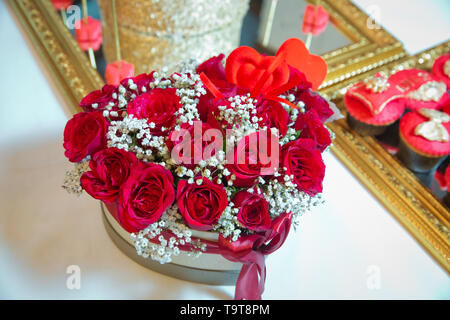 Rot und Weiß heart Bouquet. Mit einem roten Band verbunden. Handgefertigte rosa und roten Bouquet Rose In der Liebe hart-Form Valentine in Nahaufnahme. ein Feld in der Stockfoto