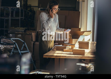 Drop-shipping Geschäft Inhaber, am Telefon zu sprechen und zu bestellen. Weibliche Unternehmer der Bestätigung der Bestellung am Telefon. Stockfoto