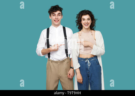 Portrait von glücklich erfolgreich zwei brünette stilvolle Partner, für Paare oder Freunde stehen und zeigen einander, und wenn man die Kamera mit toothy Lächeln. Stockfoto