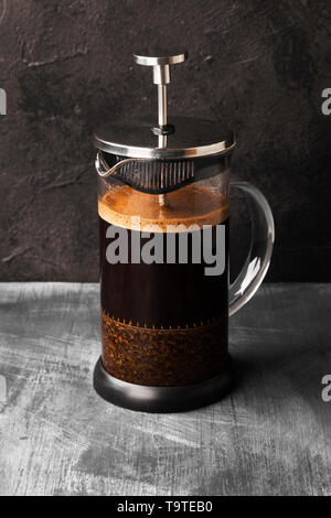 Kaffee in der französischen Presse auf dunklem Hintergrund Stockfoto