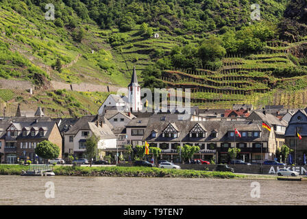 Riverside Dorf am Ufer der Mosel in Deutschland mit Weinreben auf dem Hügel Stockfoto