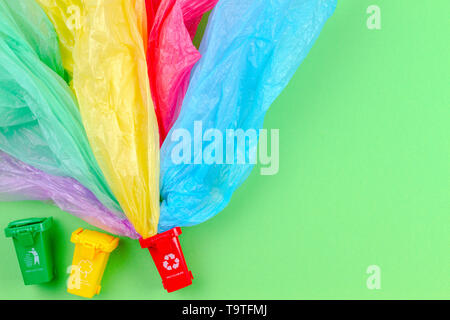 Recycling Müll Hintergrund. Bunte Papierkörbe Container mit single use Plastiktüten Stockfoto