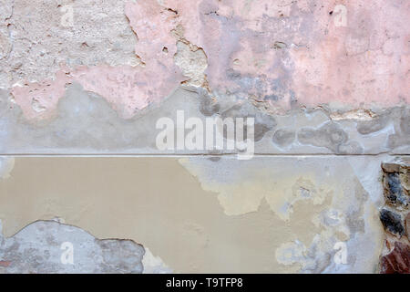 Alte verwitterte bemalte Mauer Hintergrund Textur. Beige Grau rosa schmutzig geschält Pflasterwand mit aus fallenden Flocken von Farbe Stockfoto