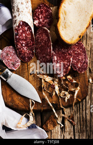 In Scheiben geschnitten ​​Salami auf Holz Schneidebrett mit Messer Stockfoto