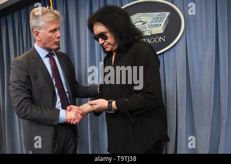 Us-Assistent der Verteidigungsminister für die Öffentlichen Angelegenheiten Charles E. Sommer Jr links, schüttelt Hände mit Rock Legende Gene Simmons von KISS während einer Meet-and-Greet am Pentagon am 16. Mai 2019 in Washington, D.C. Stockfoto
