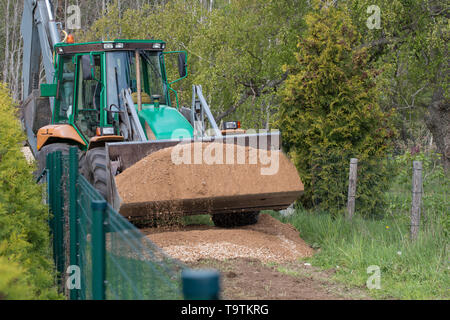 Bagger entladen, Sand, Kies, gießt der Straße in die Landschaft Stockfoto