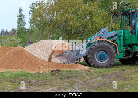 Bagger entladen, Sand, Kies, gießt der Straße in die Landschaft Stockfoto