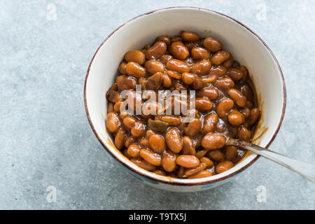 Hausgemachten Grill gebackene Bohnen in Porzellan Schüssel. Ökologische Lebensmittel. Stockfoto