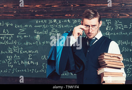 Junge Professor holding Stapel Bücher über seine Brille. Aristocrat Gelehrter in der Elite College Stockfoto