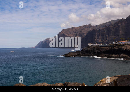 Los Gigantes Felsen in der Umgebung von Puerto de Santiago, Stadt im Westen der Insel. Im ruhigen Wasser des Atlantischen Ozeans. Blauer Himmel mit Licht Clou Stockfoto