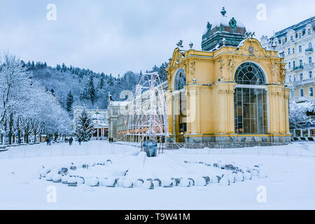 In Marianske Lazne, Tschechische Republik - 28. Dezember 2017: Winter Bild der Kolonnade aus Grauguss. Singning Wasser Brunnen vor, mit Schnee bedeckt. Stockfoto