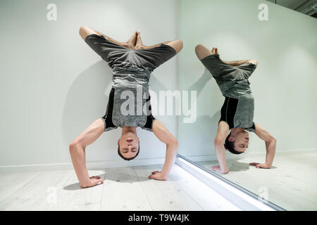 Mann lieben Sport schließen die Augen, während sie arm stand nach Yoga Stockfoto