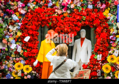 Belgravia, London, UK, 20. Mai 2019. Die Menschen nehmen Schnappschüsse von der Anzeige. Das Hotel Hari hat eine spektakuläre Herzförmige floral Display mit 60er Jahre inspirierten Figuren und eine Liebe, die mit den Passanten sehr beliebt ist - mit Fotos erstellt. Credit: Imageplotter/Alamy leben Nachrichten Stockfoto