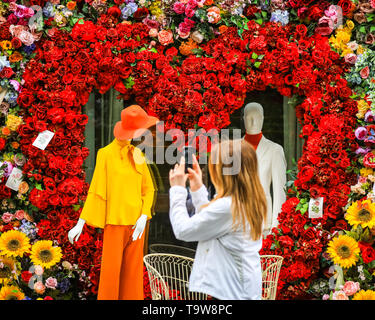 Belgravia, London, UK, 20. Mai 2019. Die Menschen nehmen Schnappschüsse von der Anzeige. Das Hotel Hari hat eine spektakuläre Herzförmige floral Display mit 60er Jahre inspirierten Figuren und eine Liebe, die mit den Passanten sehr beliebt ist - mit Fotos erstellt. Credit: Imageplotter/Alamy leben Nachrichten Stockfoto