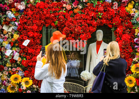 Belgravia, London, UK, 20. Mai 2019. Die Menschen nehmen Schnappschüsse von der Anzeige. Das Hotel Hari hat eine spektakuläre Herzförmige floral Display mit 60er Jahre inspirierten Figuren und eine Liebe, die mit den Passanten sehr beliebt ist - mit Fotos erstellt. Credit: Imageplotter/Alamy leben Nachrichten Stockfoto