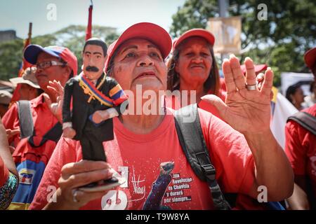 Caracas, Venezuela. 20 Mai, 2019. Ein Anhänger der venezolanische Präsident Nicolas Maduro trägt ein Maduro Puppe auf einer Kundgebung anlässlich des Jahrestages seiner Wiederwahl. Maduro übernahm den Vorsitz von Venezuela im Jahr 2013 nach dem Tod von Chavez. Er wurde am 20. Mai 2018 gewählt. Aber seit seiner Wiederwahl soll nicht zu demokratischen Prinzipien verwandelt zu haben, viele Länder nicht mehr Maduro erkennen. Credit: Pedro Mattey/dpa/Alamy leben Nachrichten Stockfoto