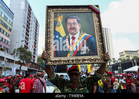 Caracas, Venezuela. 20 Mai, 2019. Ein Anhänger der venezolanische Präsident Maduro hält ein Bild von der Staatschef auf einer Kundgebung anlässlich des Jahrestages seiner Wiederwahl. Maduro übernahm den Vorsitz von Venezuela im Jahr 2013 nach dem Tod von Chavez. Er wurde am 20. Mai 2018 gewählt. Aber seit seiner Wiederwahl soll nicht zu demokratischen Prinzipien verwandelt zu haben, viele Länder nicht mehr Maduro erkennen. Credit: Pedro Mattey/dpa/Alamy leben Nachrichten Stockfoto