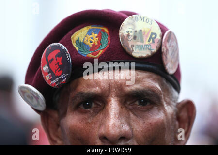 Caracas, Venezuela. 20 Mai, 2019. Ein Anhänger der venezolanische Präsident Maduro trägt eine Kappe mit Pins von Che Guevara und Hugo Chavez auf einer Kundgebung zum Jahrestag der Maduro Wiederwahl. Maduro übernahm den Vorsitz von Venezuela im Jahr 2013 nach dem Tod von Chavez. Er wurde am 20. Mai 2018 gewählt. Aber seit seiner Wiederwahl soll nicht zu demokratischen Prinzipien verwandelt zu haben, viele Länder nicht mehr Maduro erkennen. Credit: Pedro Mattey/dpa/Alamy leben Nachrichten Stockfoto