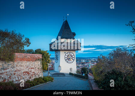 Schöne Dämmerung Blick auf berühmte Grazer Uhrturm (Uhrturm) während der Blauen Stunde in der Dämmerung, Graz, Steiermark, Österreich Stockfoto