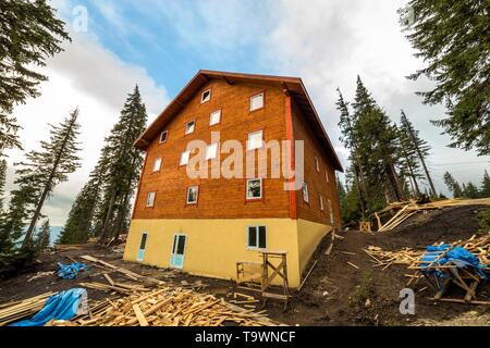 Zweistöckiges Holzhaus Hütte aus Brettern und anmeldet und blauer Himmel. Stockfoto