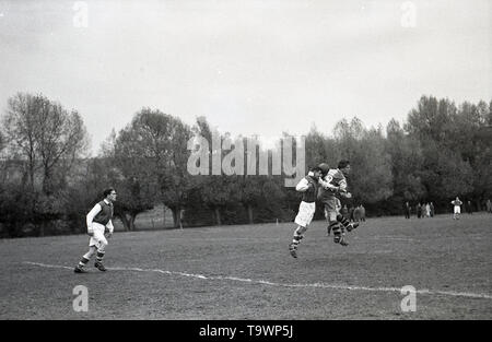 1950, historische, amateur Fußballspiel, Bild zeigt zwei Spieler, die in dem Satz des EFR, Lang, Baggy Shorts, langärmlige Hemden und knöchelhohe Stiefel konkurrieren in der Luft für den Ball, England, UK. Stockfoto