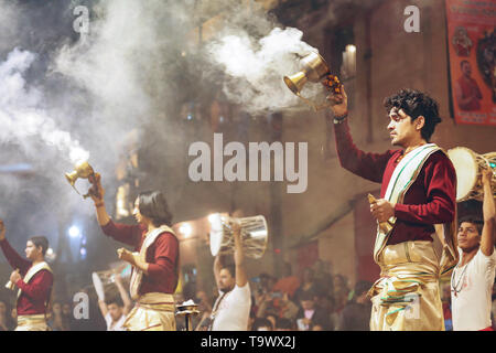 Jungen Hindu Priester durchführen Ganga Aarti rituellen Zeremonie mit Heiligem Feuer am Ghat Dashashwamedh Ganges in Varanasi Indien. Stockfoto