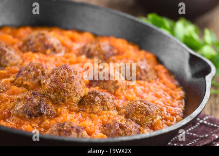 Hausgemachtes Rindfleisch Fleischbällchen in frischer Tomatensauce in Gusseisen Skillet (selektive Fokus, Fokus ein Drittel in die Sauce) Stockfoto