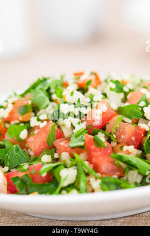 Frische vegane Tabbouleh Salat aus Tomaten, Petersilie, Zwiebel und Couscous auf Platte (selektive Fokus, Fokus in der Mitte des Bildes) Stockfoto