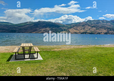 Picknickplatz mit Tisch und Bänken am Ufer des Okanagan See. Stockfoto