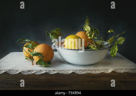 Noch immer leben von Orangen und Zitronen in einer Porzellanschale auf einem alten Holztisch Stockfoto