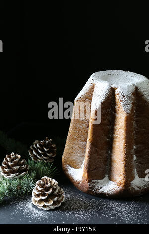 Die traditionelle italienische Weihnachtskuchen. Traditionelle italienische Weihnachtskuchen Pandoro auf dunklem Hintergrund. Weihnachtsschmuck Stockfoto