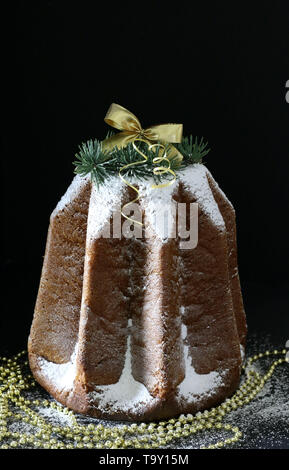 Die traditionelle italienische Weihnachtskuchen. Traditionelle italienische Weihnachtskuchen Pandoro auf dunklem Hintergrund. Weihnachtsschmuck Stockfoto