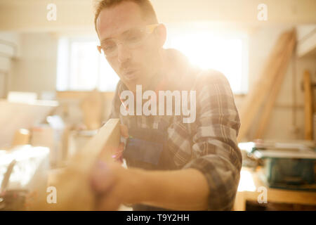 Taille bis Portrait von qualifizierten modernen Tischler arbeiten im Sonnenlicht, kopieren Raum Stockfoto