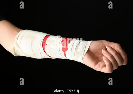 Arm der weiblichen suicider mit angewandten Bandage auf dunklem Hintergrund Stockfoto