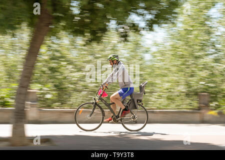 Cordoba, Spanien - 10. Mai 2019: Gesunde Radfahrer mit Helm und Sport Shorts Reiten durch die Straße. Stockfoto