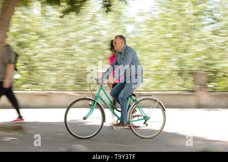 Cordoba, Spanien - 10. Mai 2019: Reifen Radfahrer mit einem klassischen Fahrrad fahren durch die Straße. Stockfoto